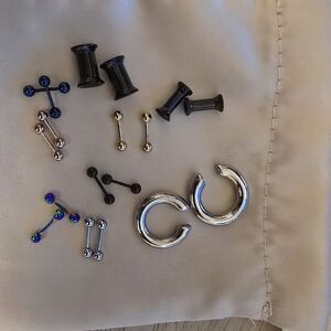 Body piercing jewelry, including huggies, black plugs, and barbells